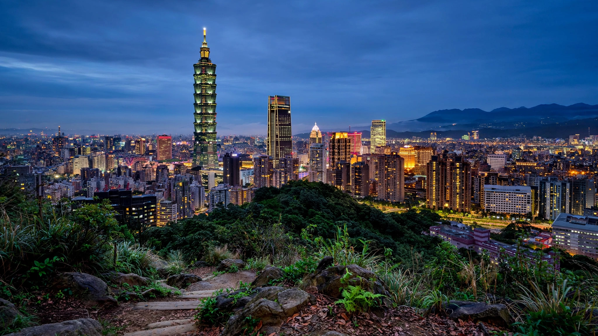 Taipei skyline with Taipei 101 over city and hills at blue hour